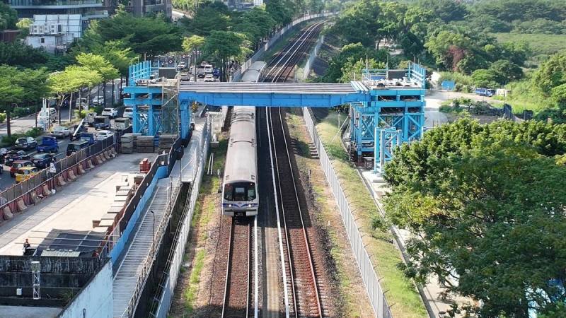 跨越紅樹林捷運站施工便橋主梁吊裝完成，10月中旬起可提供大型機具進出臨河側淡北道路工區施工。   圖：新北市政府新工處/提供