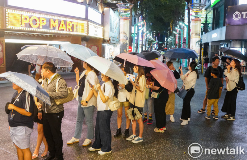 一些民眾和外籍旅客在西門町排隊購買台灣美食。   圖：張良一/攝