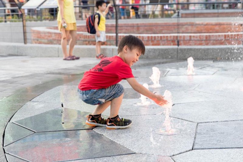 柯文哲於FB貼出孩子在建成圓環戲水照，夏日炎炎，孩子也想摸摸冰涼的噴泉水。   圖：翻攝自柯文哲FB頁面