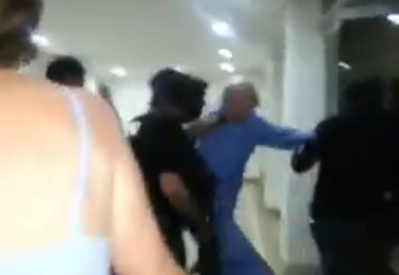 62歲的雷戴茲馬（藍衣者）遭委內瑞拉國家情報局人員粗暴地拖走，過程全都錄成影片上傳。   圖：翻攝雷戴茲馬推特