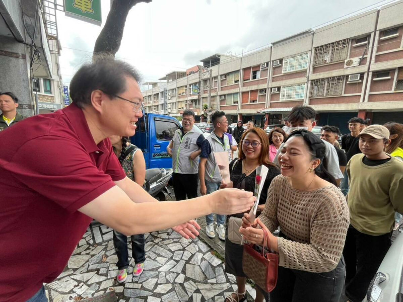 民進黨花蓮縣黨部舉行「新住民諮詢站」揭牌儀式暨座談會，秘書長林右昌向在場的新住民朋友們獻上玫瑰花祝福。   圖：民進黨提供