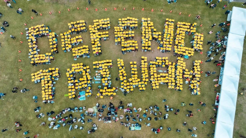 黑熊學院7日完成千人排字「DEFEND TAIWAN」展現守護民主的精神活動。   圖：翻攝自黑熊學院臉書