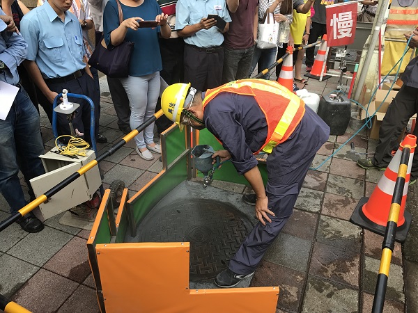 人孔蓋抗滑材料噴塗作業進行中。   圖：台北新工處提供
