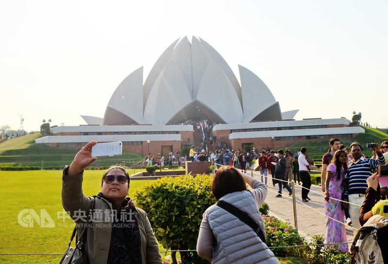 在印度知名景點，經常可看到民眾以手機自拍。圖為印度每年遊客最多的知名景點蓮花寺前，許多人拿著手機自拍。   圖：中央通訊社提供