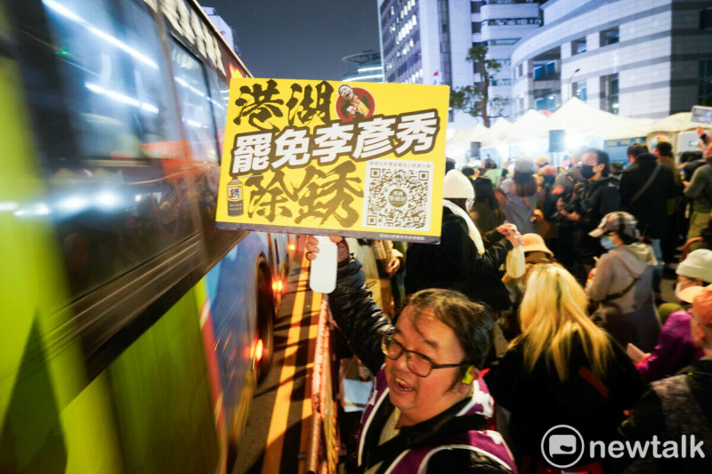 一位市民拿著『罷免李彥秀 除銹』手板，向經過的市民表達訴求。   圖：張良一/攝