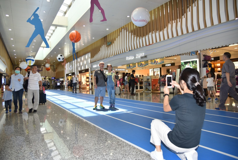 D區登機長廊具各種球類競賽意象的田徑跑道裝置藝術，吸引許多旅客拍照打卡   圖：桃園機場提供