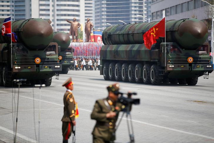 北韓領導人金正恩率文武百官，在閱兵台上校閱洲際彈道飛彈車隊。   圖：達志影像／路透社