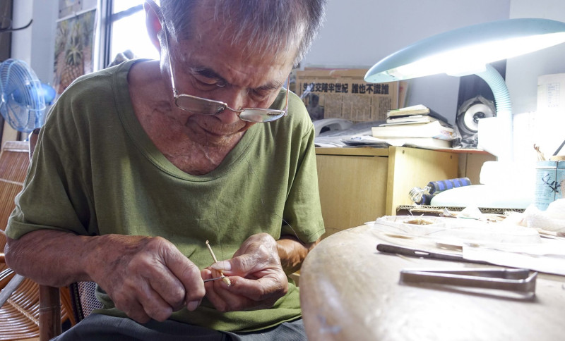 傳承七十多年的兩美理髮店第三代傳人許先生，正在手工製作台灣僅存的耳挖絨球。   張大魯/攝影