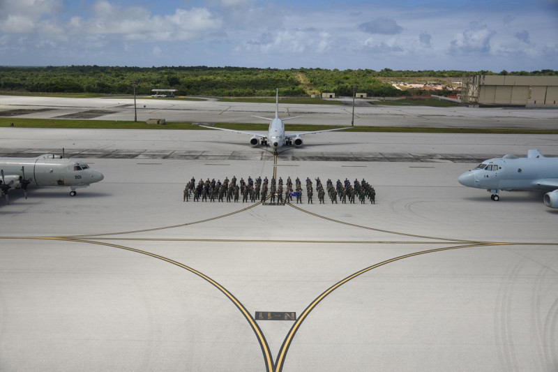 來自澳洲皇家空軍（RAAF）、印度海軍、日本海上自衛隊（JMSDF）、大韓民國海軍（ROKN）與美國海軍的參與者，於 3 月 13 日在關島安德森空軍基地合影留念。背景展示了韓國海軍 P-3「獵戶座」（左）、澳洲皇家空軍 P-8A「波賽頓」（中）與日本海上自衛隊的川崎 P-1（右）巡邏機。   圖：美國海軍 提供