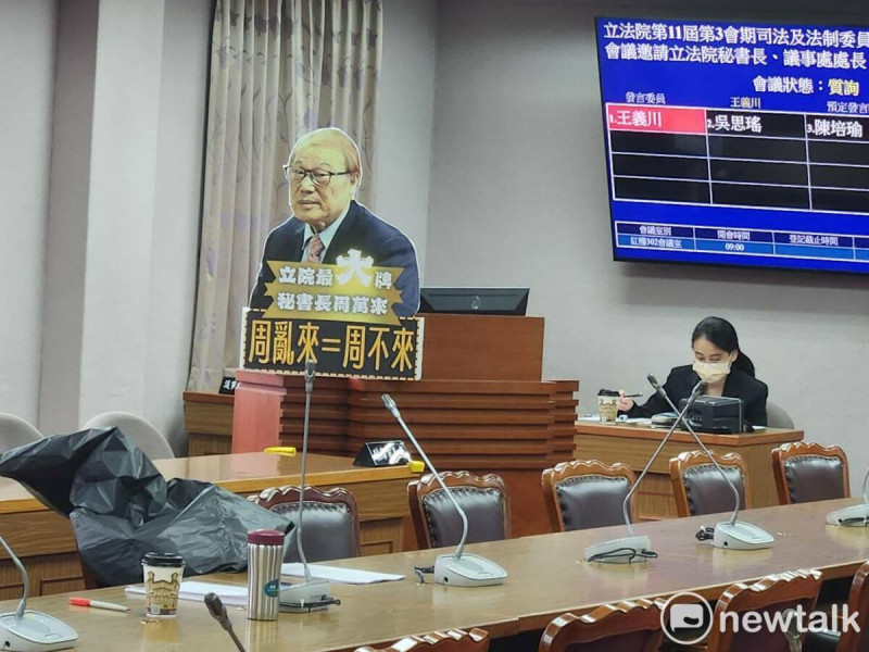 委員會議室現場放著寫有「立法院最大牌秘書長周萬來，周亂來=周不來」字樣的道具版。   圖：黃建豪/攝