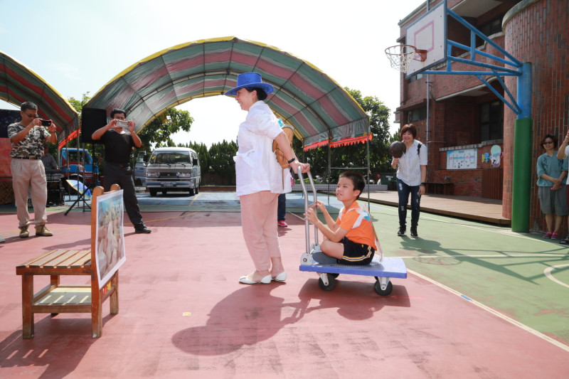 同心協力趣味競賽，張花冠現場用拖車拉著小男生進行示範。   圖：嘉義縣政府提供。