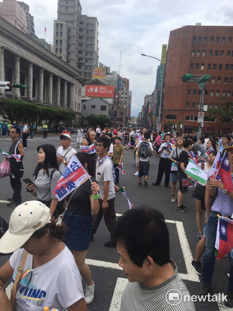 手持國持與台灣國旗幟的民眾在路旁等待遊行車隊。   圖 : 張正霖/攝