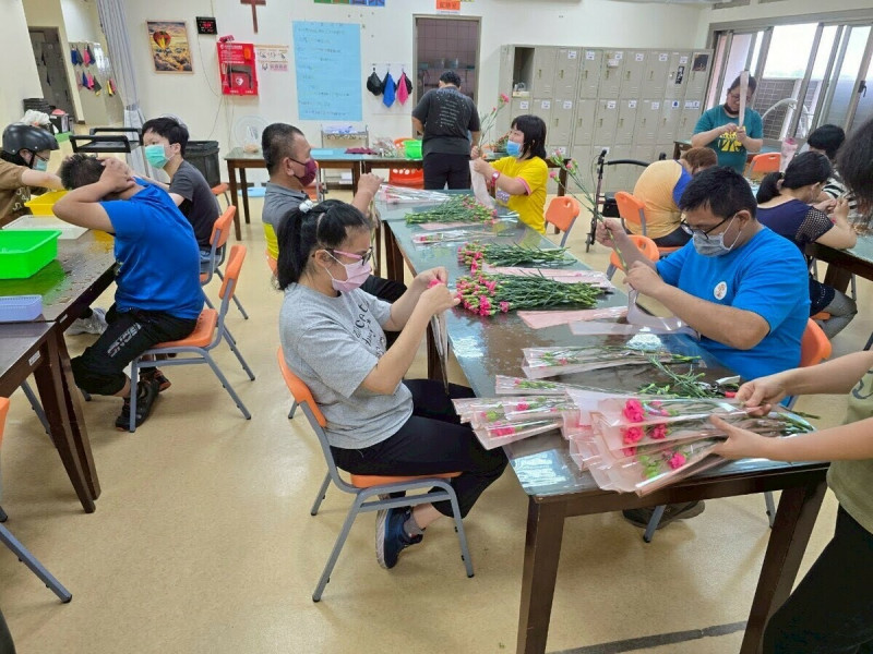 豐邑集團與瑪喜樂慢飛天使與彰化花農，採購包裝康乃馨，於母親節前送至各社區。   圖：豐邑集團/提供