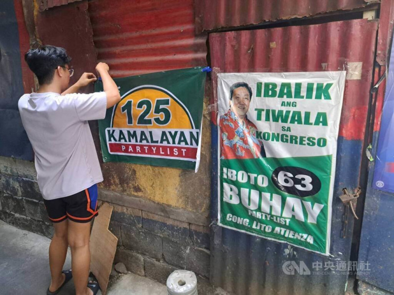 菲律賓12日將舉行期中選舉，改選參議院24席中的12席，選出眾議院317席，以及各省市鎮地方首長和地方議員，總計1萬8200多人。圖為馬尼拉民眾為支持的候選人整理海報。中央社記者林行健馬尼拉攝 114年5月11日   