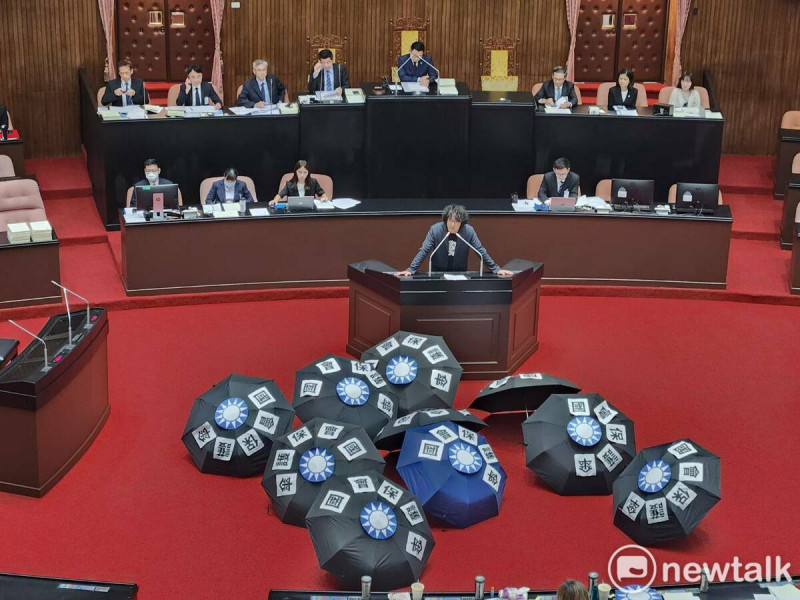民進黨團反對立法院延會，更在地上擺放貼上「國會保護傘」字樣與國民黨徽的十把傘。   圖：黃建豪/攝