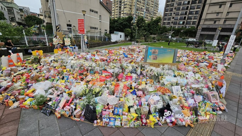 新北市三峽區19日發生重大傷亡車禍,許多民眾主動獻花,事發路口的公園陸續擺滿了各種零食飲料、鮮花及可愛玩偶。中央社記者王鴻國攝 114年5月21日