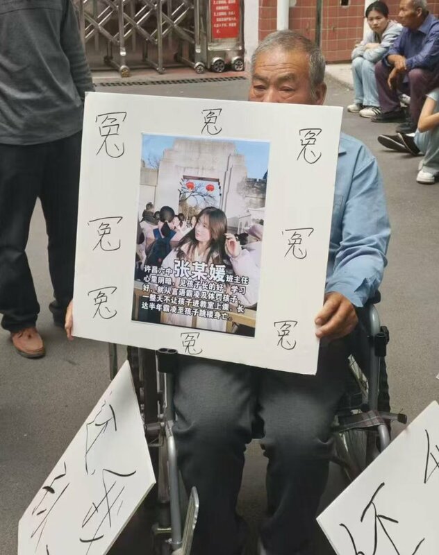 死者爺爺在學校門口舉牌，控訴其班主任張某媛導致孩子自殺。 圖:翻攝自X帳號@whyyoutouzhele