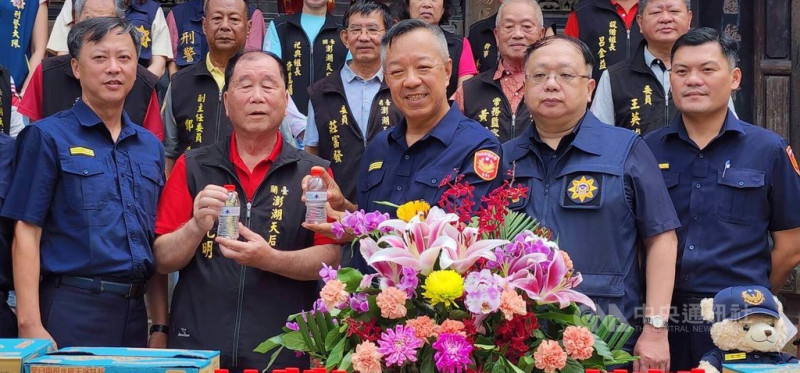 澎湖天后宮「保庇防詐水」贈水儀式,28日在天后宮前往廣場舉行,主委蔡光明(前左2)捐贈印有「保庇防詐水」字樣瓶裝水,澎湖縣警察局長林温柔率(前中)所轄3個分局長等代表接受,並回贈感謝狀給天后宮,現場也正好大批遊客前往參觀,分享防詐水保佑。中央社 114年5月28日