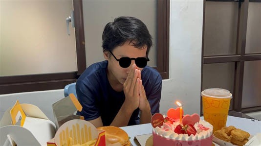 黃姓青年17日度過人生第一個生日，開心對著生日蛋糕許願，社工特地幫他梳頭打扮拍照留念。   圖：台中市社會局提供