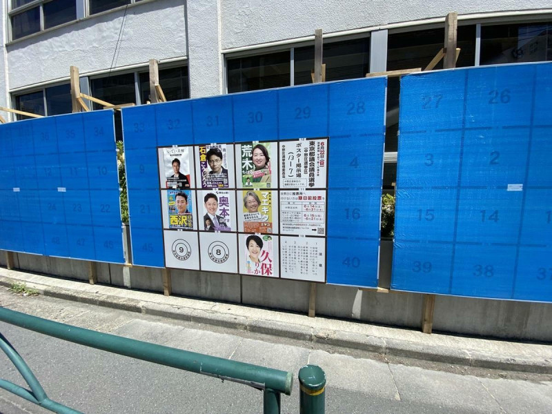 東京都議員選舉後就是7月參議員選舉，因此選舉告示板做很大，用藍色塑膠布蓋住下個月要給參議員選舉用的部分，兩大選舉如此接近是第一次，這樣的選舉板也是首見！   圖: 劉黎兒/攝影