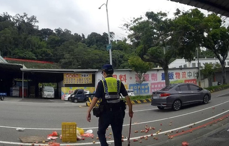 57歲黃姓果農日前載著桃子要到市場販售，在台中市石岡區豐勢路與另輛機車發生碰撞，桃子散落一地，警方與附近居民一同協助清理。（民眾提供）中央社記者趙麗妍傳真  114年6月26日   