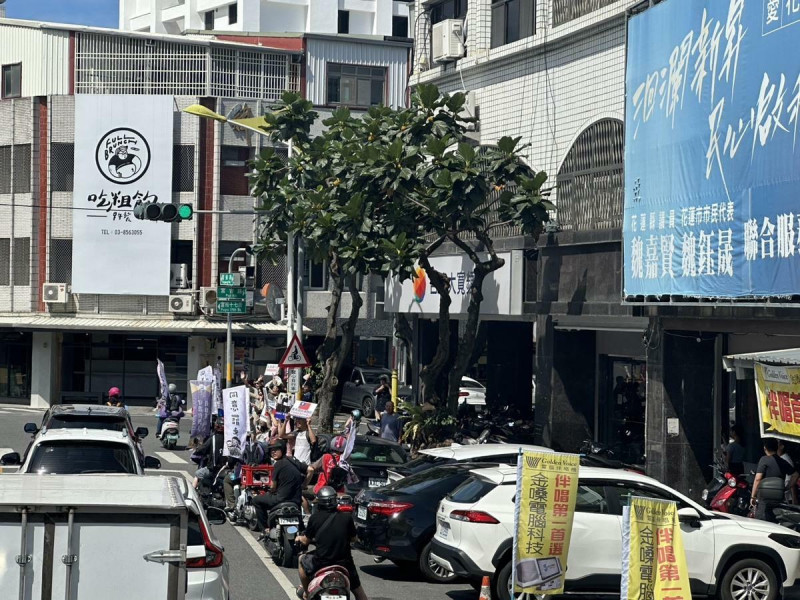「護國大遶境」車隊途經魏嘉賢服務處,有人拿著「心中有國旗,罷免傅崐萁」看板,周遭也放起鞭炮。 圖:讀者提供