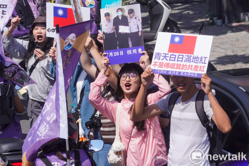 護國大遶境首日從花蓮出發，花蓮市民高舉著傅崐萁被法警帶出庭以及青天白日滿地紅的國旗，並在手舉牌上寫著：「青天白日滿地紅不是傅崐萁的共產紅」以及「7月26日投同意，站在路口歡迎護國大遶境的香燈腳。   圖：張良一/攝