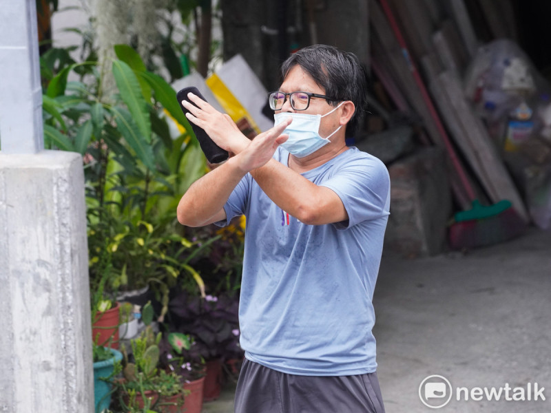 一位花蓮市民在胸前比出打叉手勢,參加護國大遶境車隊掃街的罷團志工則是高舉手臂手比愛心回應。 圖:張良一/攝