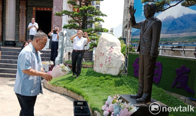 余政憲(左一)向安倍銅像獻花致意。 圖:孫家銘攝