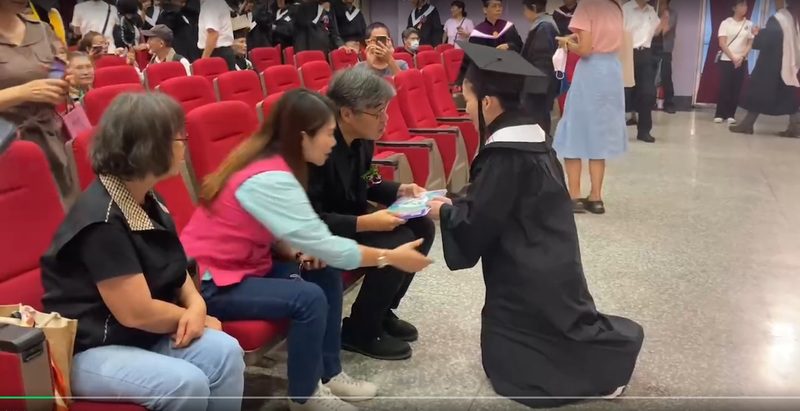 高雄空大一名女畢業生下跪向李懷仁(左三)及李雅靜(左二)遞交具名陳情書。   圖：讀者提供