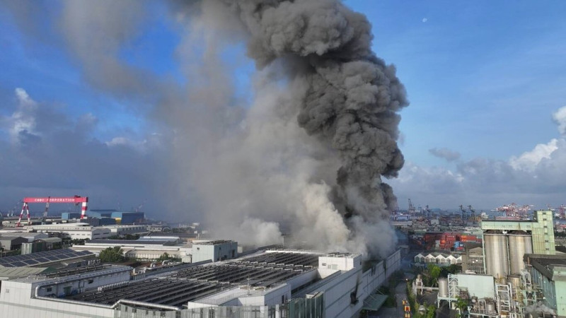 高雄市小港區三元能源公司建築14日清晨5時許發生火警，現場建築冒出大量濃煙，經消防員布水線灌救，火勢持續控制中。   圖：高雄市政府消防局提供