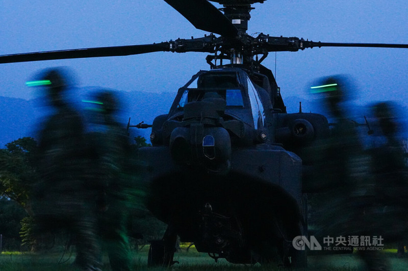 AH-64E阿帕契攻擊直升機17日晚間實施夜間熱加油及掛彈訓練，圖為官兵配戴綠色頭燈列隊經過阿帕契機頭。中央社記者游凱翔攝  114年7月17日   圖：中央社提供