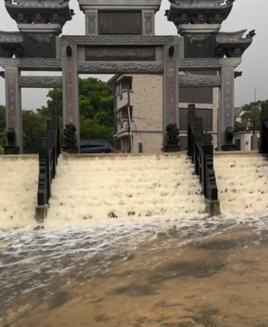 金門部分地區累積雨量已達103.5毫米，強烈雨勢導致各地災情頻傳。水流甚至從陳氏宗祠牌坊前的階梯湧入，形成小型瀑布。   圖：翻攝臉書「金門記者爆料網」粉專