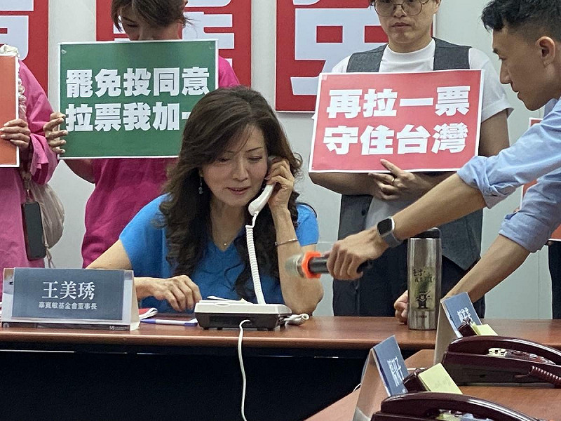 辜寬敏基金會23日舉行「再拉一票 守住台灣」行動記者會,董事長王美琇打電話給人在花蓮的政治受難者陳列 圖:林朝億/攝