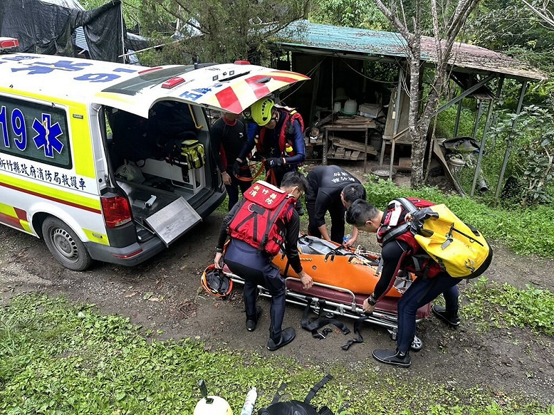45歲莊姓男子27日在新竹縣五峰鄉雙龍瀑布溯溪時不慎落水，同行隊員將其拉起施以心肺復甦術（CPR）無效，消防局表示，搜救人員運用捲式擔架與繩索，逆流溯溪、跨越困難地形，將其搬運至道路後送醫，但家屬放棄急救。（新竹縣消防局提供）中央社記者魯鋼駿傳真　114年7月27日   