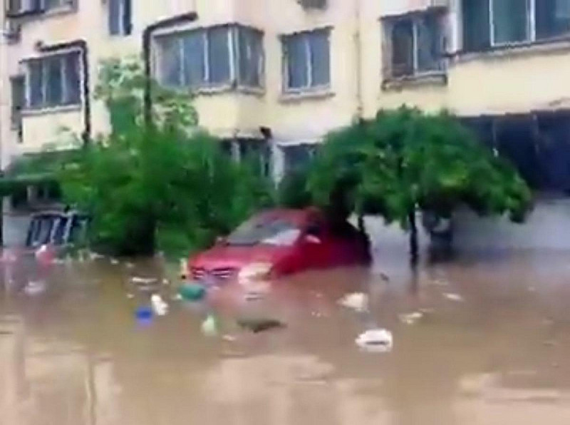 北京洪災導致社區內的車輛「泡水」。   圖：擷取自網路影片