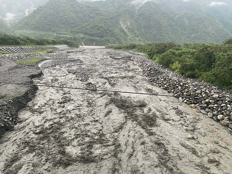 信義鄉明德村與水里鄉上安村交界的保甲林溪，經過整夜豪雨，發生嚴重土石流，大量土石灌入防汛道路，導致信義鄉忠信社區對外交通完全中斷。   圖：信義鄉明德村長吳瑞龍提供