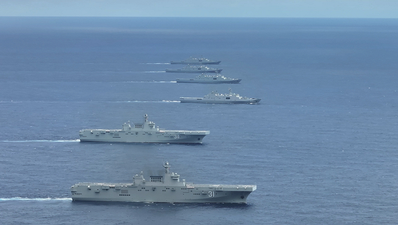 新華網報導,075型兩棲攻擊艦海南號(鏡頭前第1艘)、湖北號(第2艘)與至少4艘護衛艦在南海某海域進行實戰化訓練。 圖:翻攝新華網