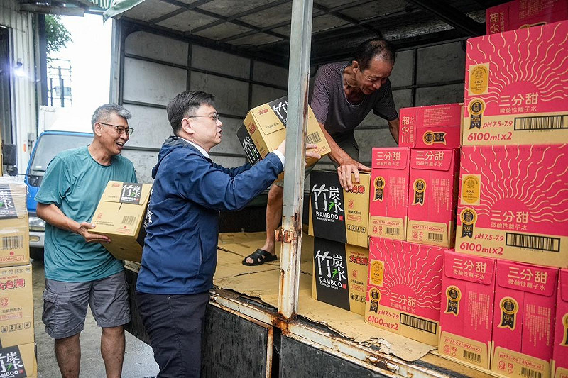 賴瑞隆(中)下場協助搬運民生物資上車送進山區。   圖：賴瑞隆辦公室/提供