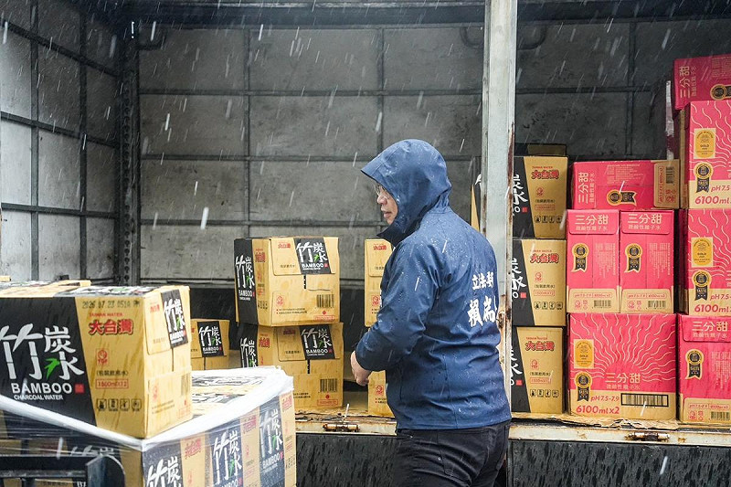 賴瑞隆冒雨協助搬運民生物資。   圖：賴瑞隆辦公室/提供