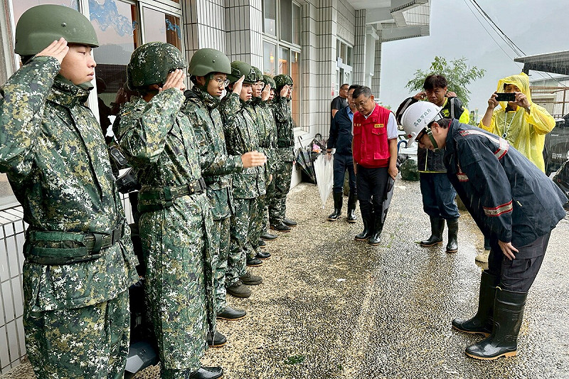 其邁(右一)向辛苦救災的阿兵哥鞠躬致謝。 圖:高雄市政府/提供
