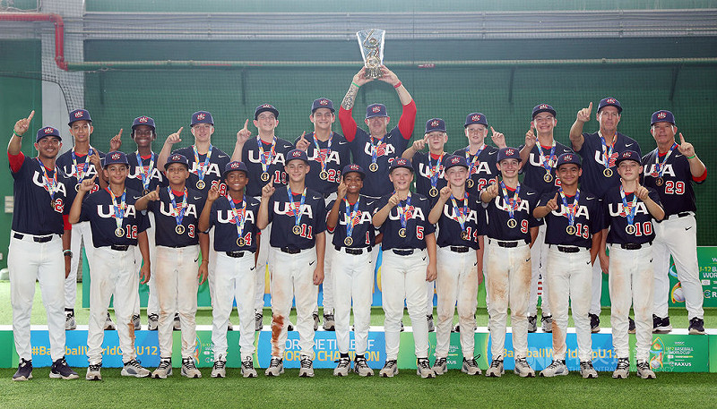 U12世界盃棒球賽美國隊3日冠軍戰以7比1擊敗日本隊、完成3連霸;總教練馬德森(舉獎盃者)頒獎典禮時高舉獎盃與全隊合影。中央社記者張新偉攝 114年8月3日