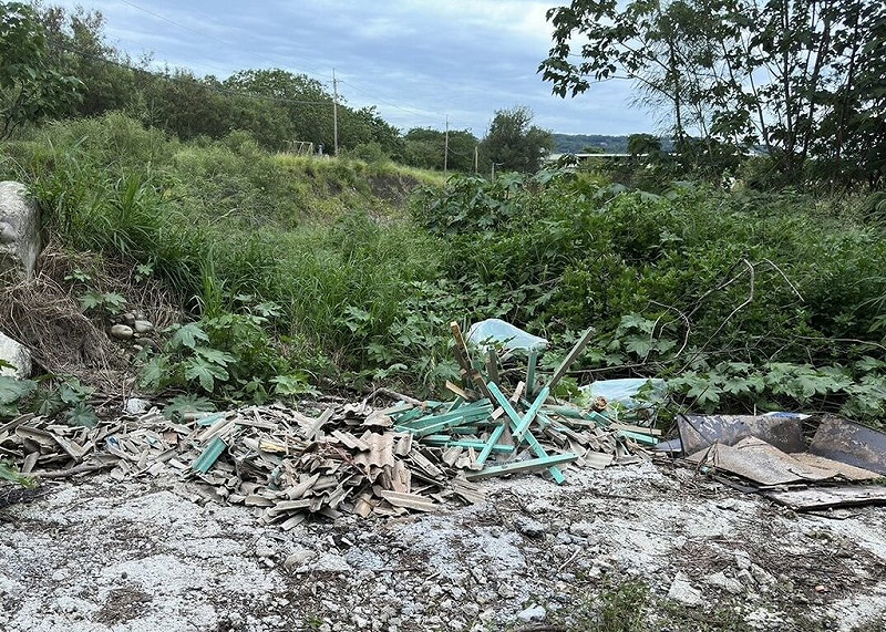 苗栗縣銅鑼鄉國道高架下日前遭人傾倒石棉瓦等廢棄物，警方7日表示，從現場遺留1張疑似廠商的貨物單據，查出湯姓男子（53歲）修繕房屋後任意棄置，依廢棄物清理法送辦。（警方提供）中央社記者管瑞平傳真　114年8月7日   
