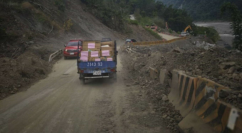 送物資車隊前進山區沿途可見部分山路仍中斷,在安全人員指引下小心繞行臨時便道,冒險跨過落石阻隔的路段。 圖:國民黨高雄市黨部/提供