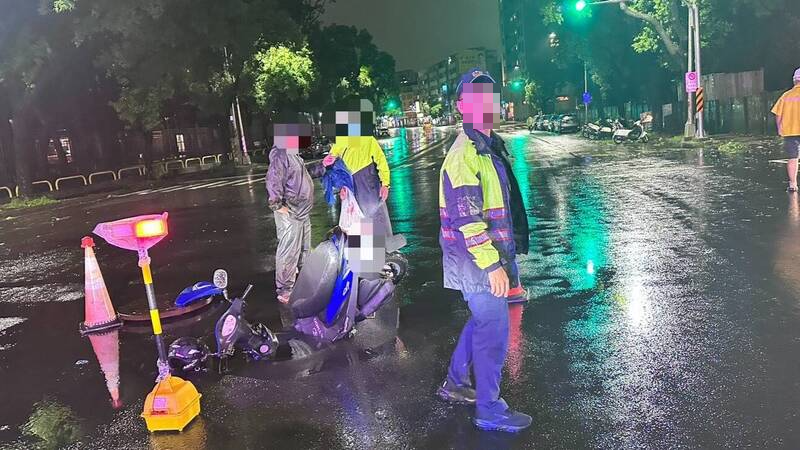 一名婦人騎機車在路口欲左轉行駛時，不慎陷入因人孔蓋位移而導致坑洞，所幸車頭剛好卡入洞口，才沒釀成更大意外。   圖：民眾／提供