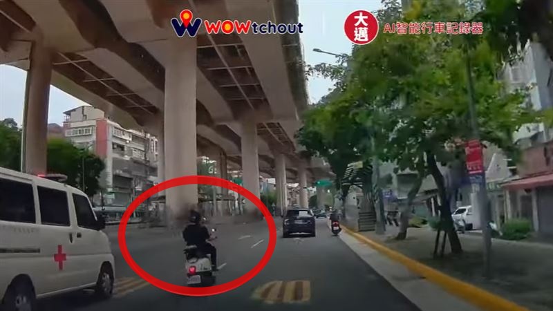 機車騎士為趕黃燈竟超車鳴笛中救護車。   圖：取自WoWtchout - 地圖型行車影像分享平台