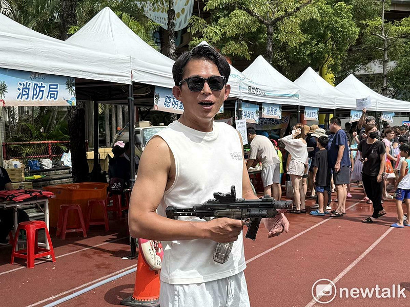 民眾黨主席黃國昌今出席民眾黨新北市議員陳世軒舉辦的「JIMMY搖滾水樂園」，手持水槍。   圖：周煊惠 / 攝