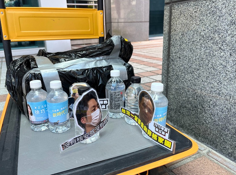 陳聖文帶著印有台北市長蔣萬安、國民黨主席朱立倫、民眾黨主席黃國昌、國民黨立委徐巧芯、羅智強等人像印刷品的瓶裝水到國民黨中央黨部。   圖：國民黨/提供