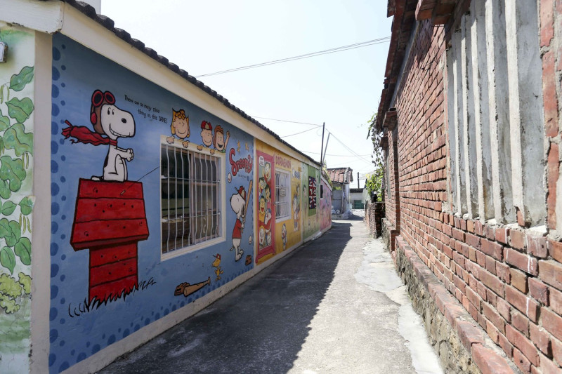 Kevin牆上彩繪作品不限於龍貓，讓遊客在巷弄內驚喜的與各式漫畫人物合影。   張大鲁/攝影