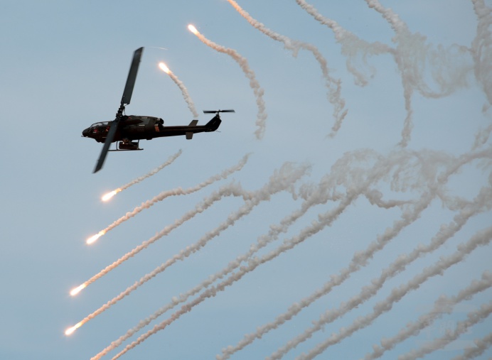 陸軍AH-1眼鏡蛇攻擊直升機配合十軍團重砲射擊，在空中施放熱焰彈，模擬對敵實施干擾，透過聯合操演，提升聯戰效能。軍聞社記者李忠軒攝。   圖：取自軍聞社官網／李忠軒攝